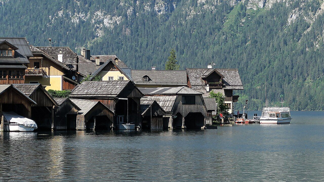 Wooden boathouses on the shore of the Hallstätter See in Hallstatt, with mountains behind