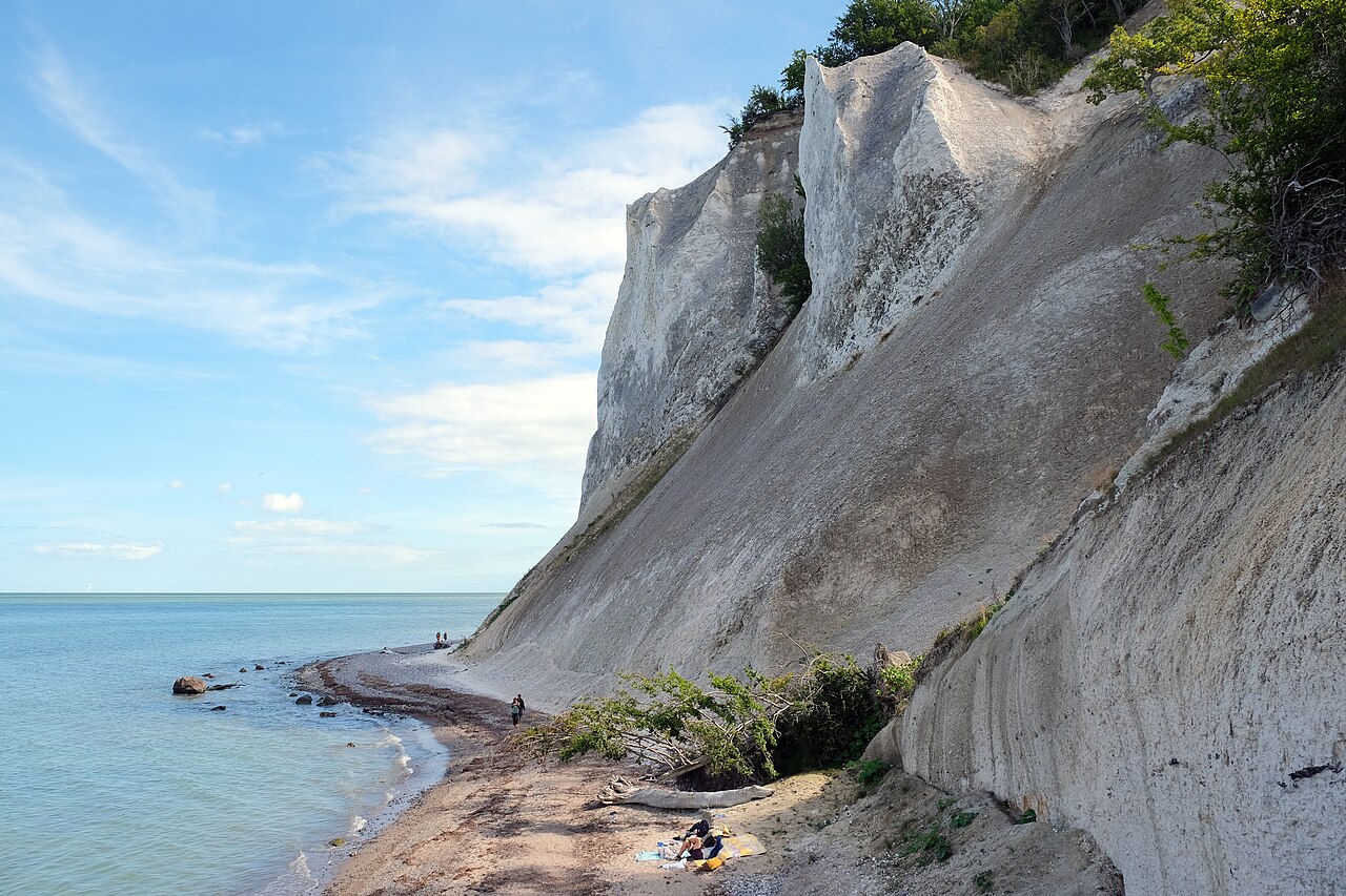 White chalk cliffs rising above a pebble beach and the sea at Møns Klint in Denmark