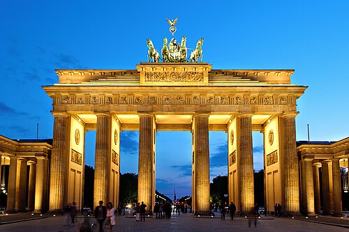 The Brandenburg Gate in Berlin lit at dusk with a purple sky