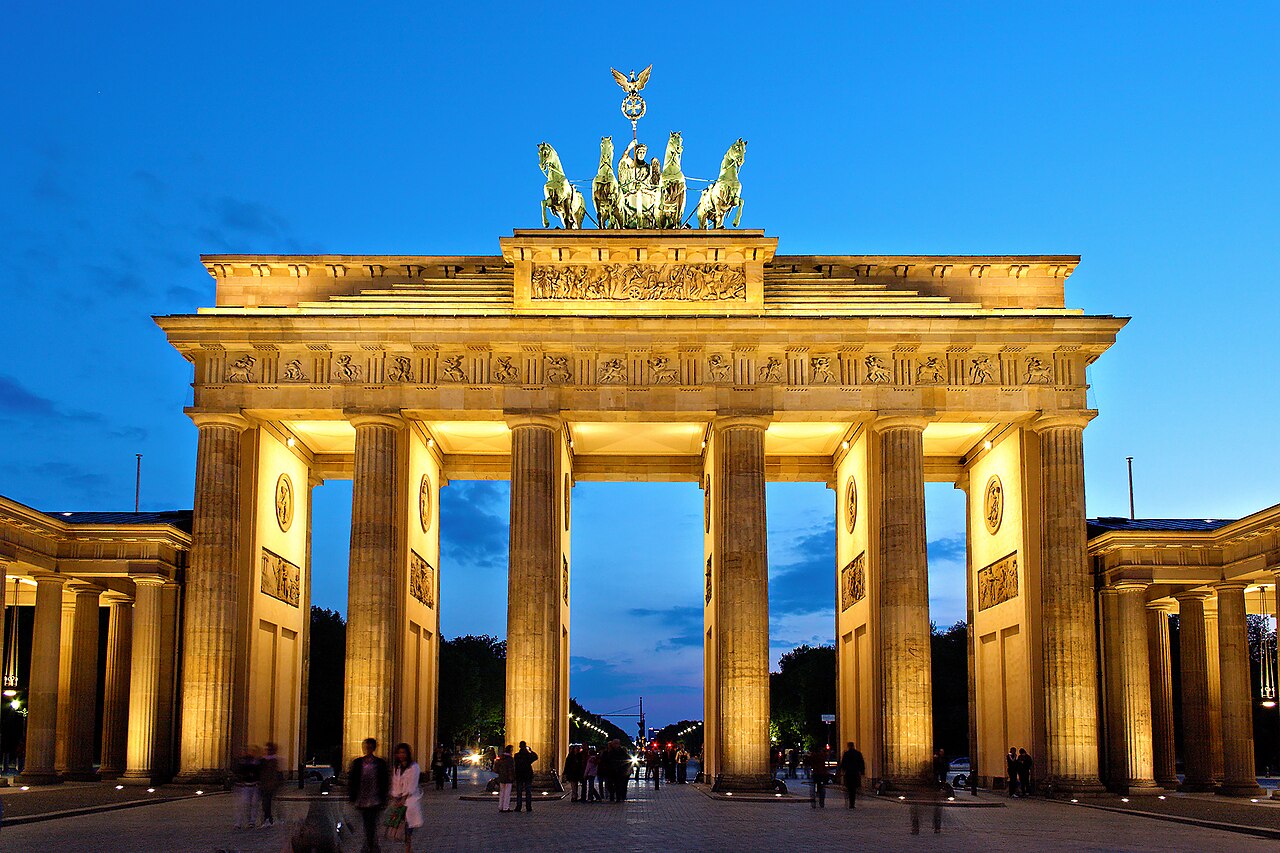The Brandenburg Gate in Berlin lit at dusk with a purple sky