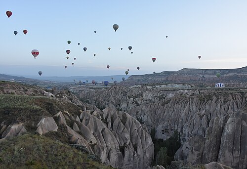 Hot air balloons rising over the rock valleys near Göreme at dawn