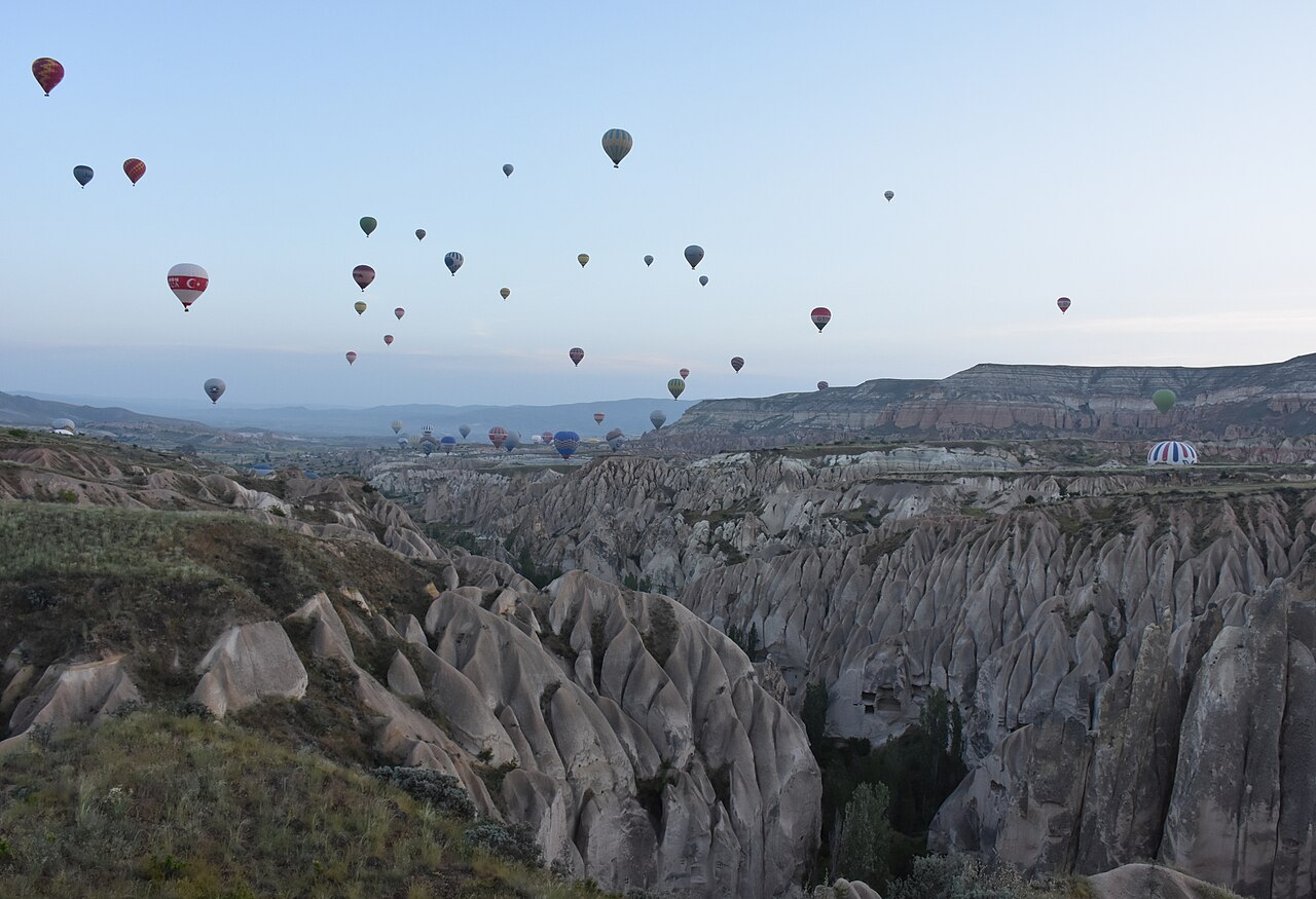 Hot air balloons rising over the rock valleys near Göreme at dawn