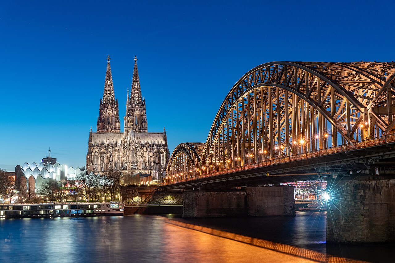 Cologne Cathedral and the illuminated Hohenzollern Bridge over the Rhine at blue hour