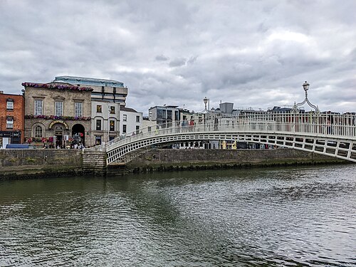The Ha'penny Bridge, a white cast iron footbridge, arching over the River Liffey in Dublin