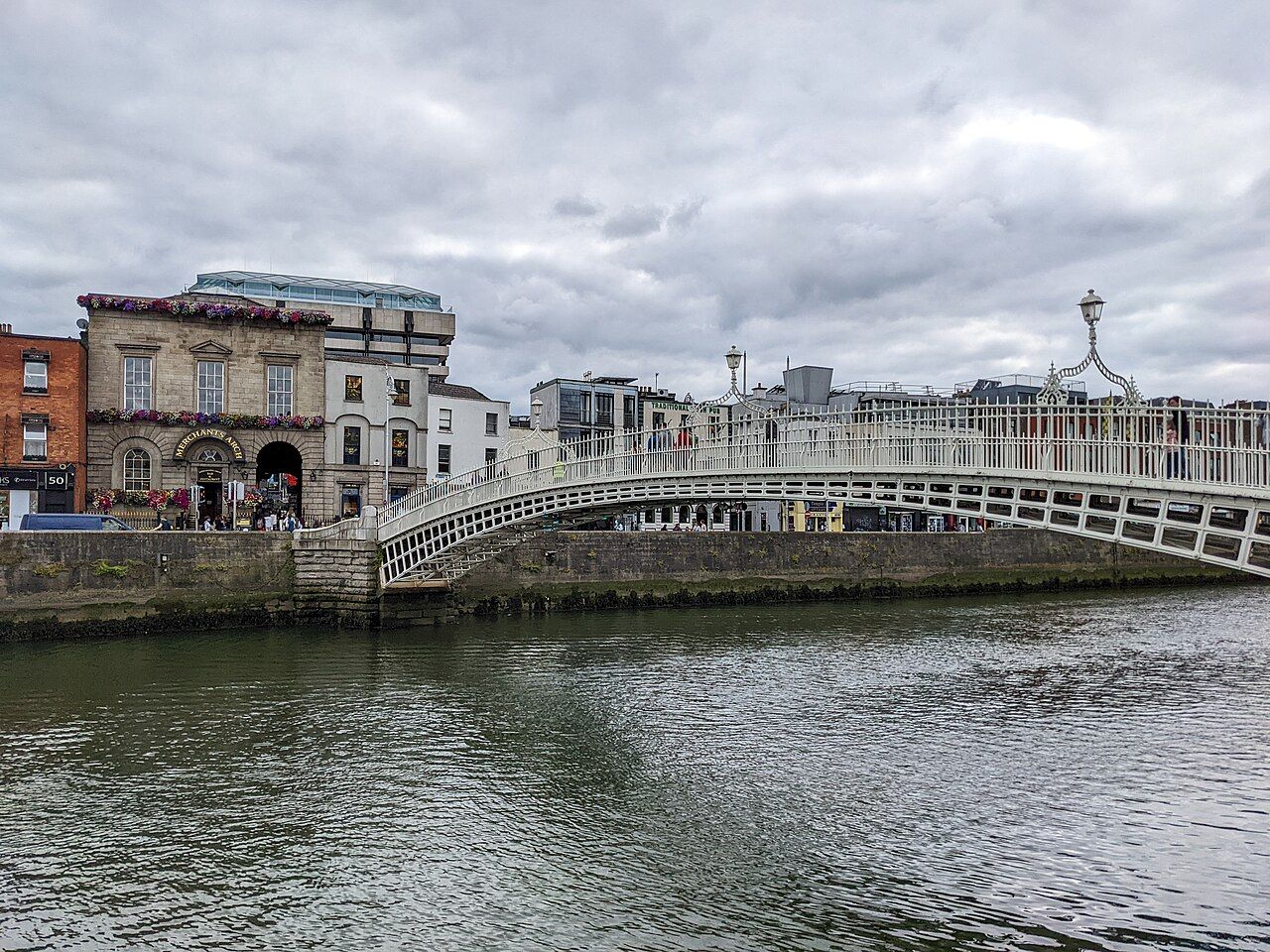The Ha'penny Bridge, a white cast iron footbridge, arching over the River Liffey in Dublin