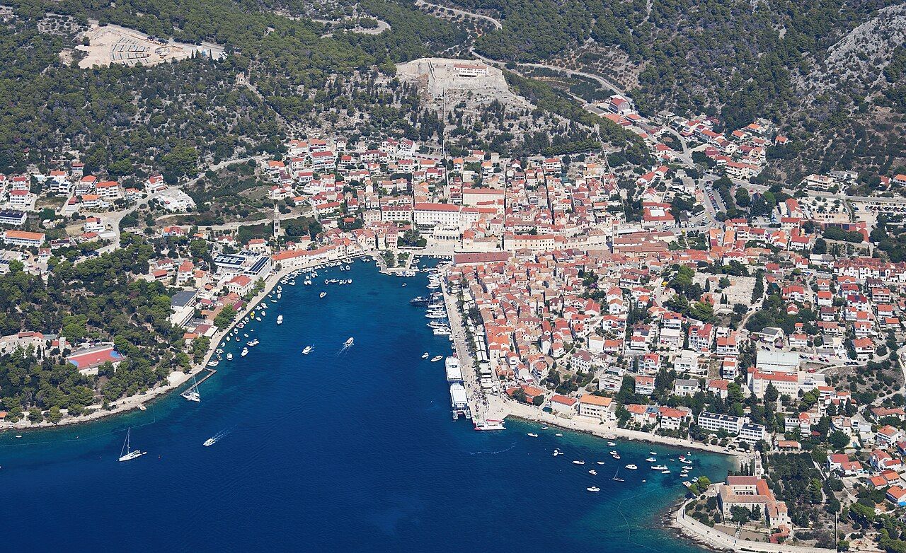 Aerial view of Hvar town from the south, with its harbor, red roofs and the Spanjola fortress on the hill