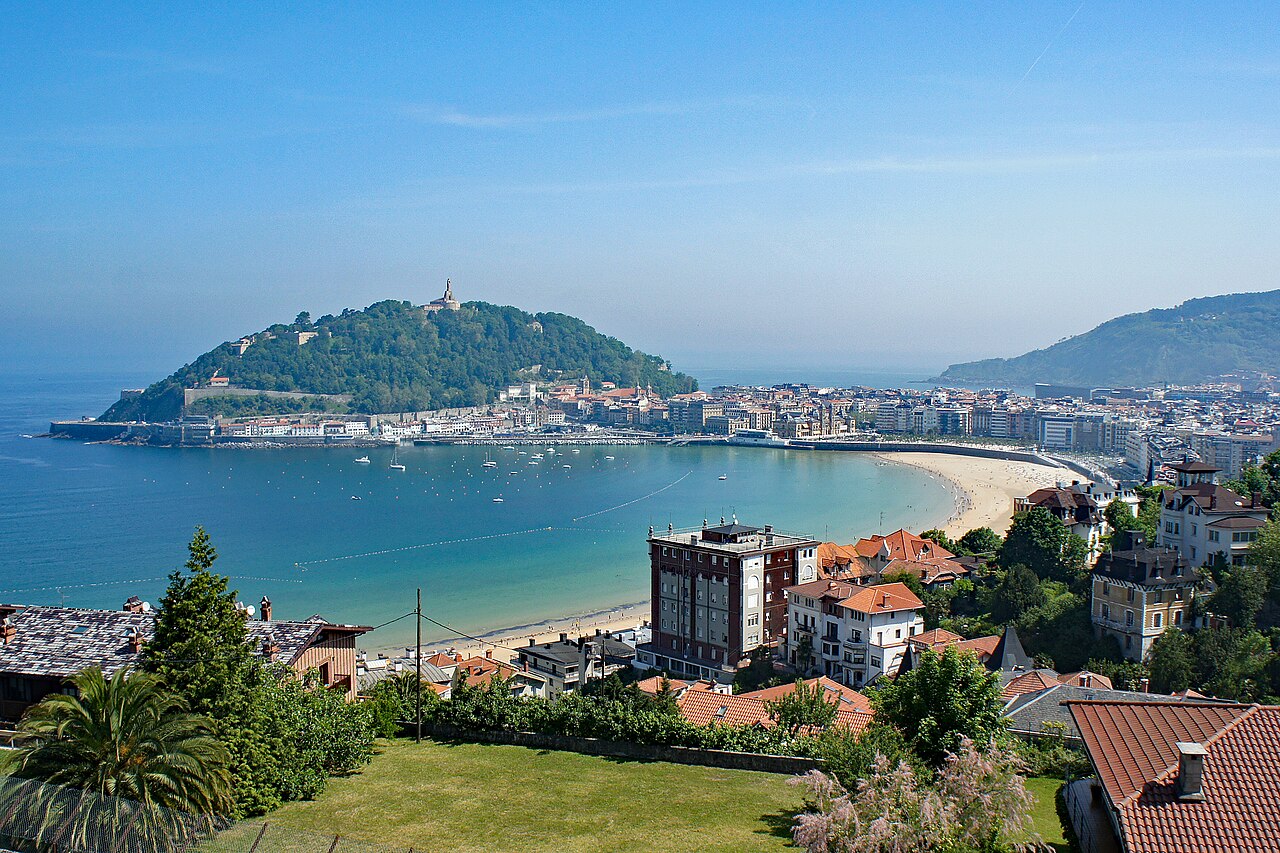 The curve of La Concha bay in San Sebastián seen from above, with the beach, the promenade and the city behind