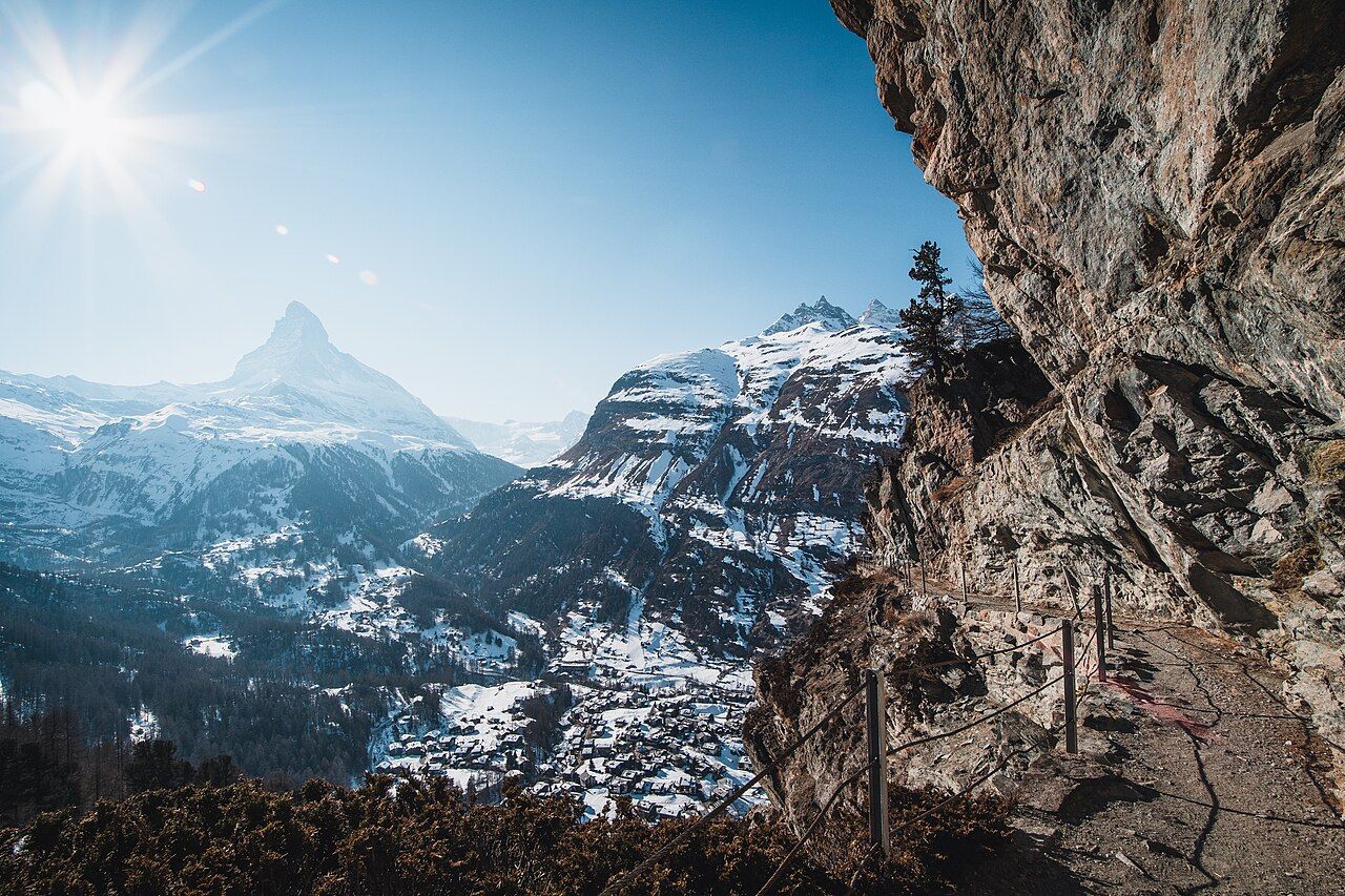 The Matterhorn above the chalets and church of Zermatt village on a sunny winter afternoon