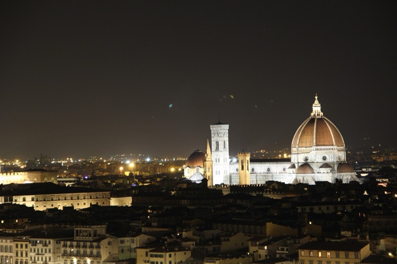 The Duomo lit up at night above Florence's rooftops